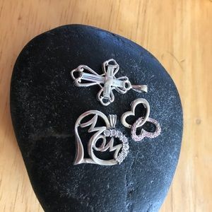 Three sterling silver pendants.